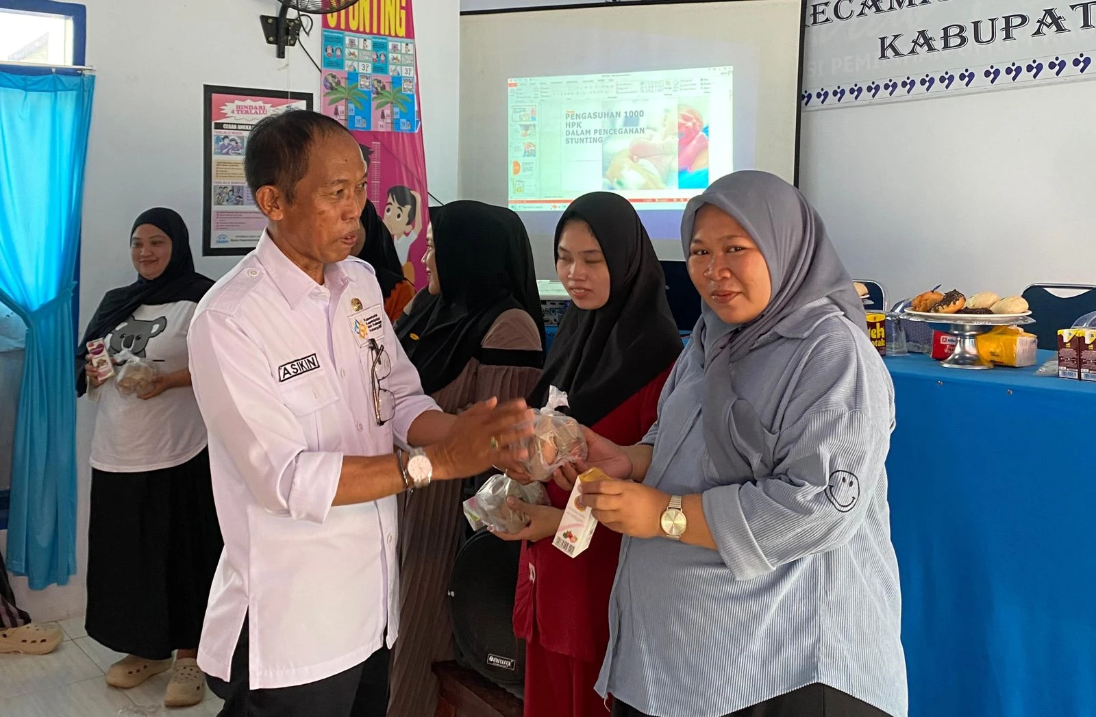 H. Asikin menyerahkan bantuan makanan bergizi berupa telur dan susu kepada ibu hamil dalam kegiatan sosialisasi pencegahan stunting bertema “Awasi 1000 Hari Pertama Anak” di Kelurahan Sompe, Kabupaten Wajo, Rabu (23/7/2025). Kegiatan ini merupakan kolaborasi antara mahasiswa KKN 114 Unhas dan pemerintah kelurahan untuk meningkatkan kesadaran pentingnya gizi sejak masa kehamilan sebagai investasi generasi masa depan. Kredit: Dokumentasi KKN 114 Unhas.
